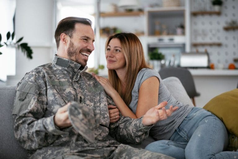 Featured image for Military Spouse Benefits showing a male Servicemember and his wife on the couch