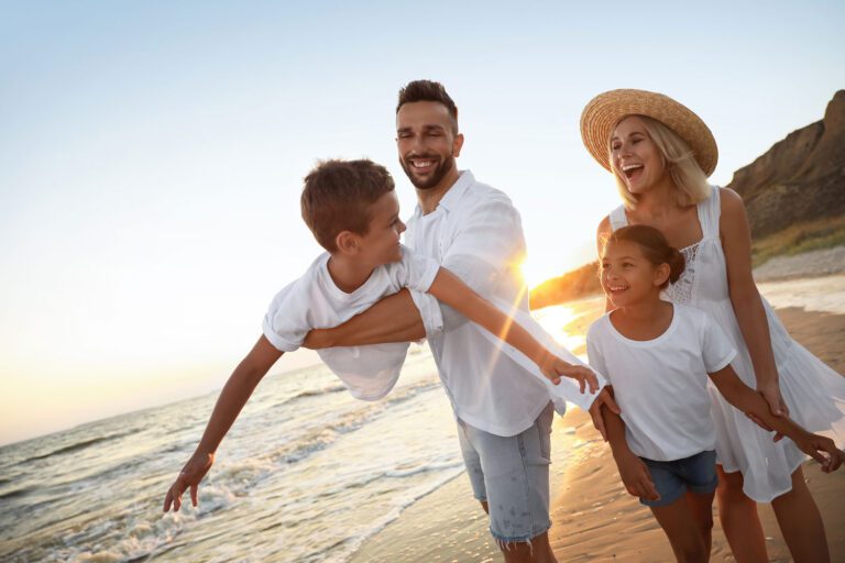 Featured image for American Forces Travel showing a happy Military family on vacation by the beach