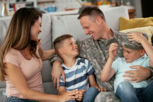 Featured image for TRICARE, showing a happy military family in their living room