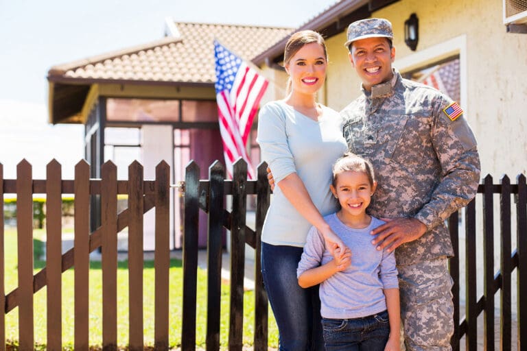 Featured image for VA Loan Refinancing, showing a happy military family in front of their home